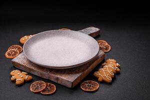 Empty round ceramic copy space plate with gingerbread cookies and Christmas elements photo