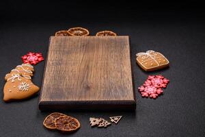 Empty wooden cutting board with copy space with gingerbread cookies and Christmas decor photo
