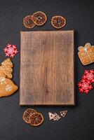 Empty wooden cutting board with copy space with gingerbread cookies and Christmas decor photo