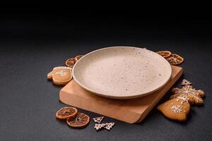 Empty round ceramic copy space plate with gingerbread cookies and Christmas elements photo