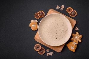 Empty round ceramic copy space plate with gingerbread cookies and Christmas elements photo