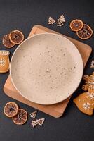 Empty round ceramic copy space plate with gingerbread cookies and Christmas elements photo