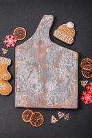 Empty wooden cutting board with copy space with gingerbread cookies and Christmas decor photo