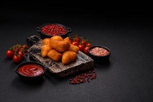Breaded camembert or brie cheese baked in the form of nuggets with salt and spices photo