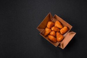 Breaded camembert or brie cheese baked in the form of nuggets with salt and spices photo