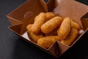 Fast food breaded cheese sticks with salt and spices photo