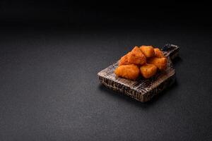 Breaded camembert or brie cheese baked in the form of nuggets with salt and spices photo