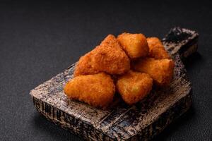 Breaded camembert or brie cheese baked in the form of nuggets with salt and spices photo