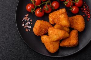Breaded camembert or brie cheese baked in the form of nuggets with salt and spices photo