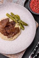 Juicy beef or pork cut into slices with boiled asparagus photo