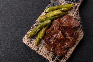 Juicy beef or pork cut into slices with boiled asparagus photo