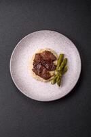 Juicy beef or pork cut into slices with boiled asparagus photo