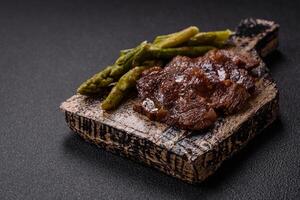Juicy beef or pork cut into slices with boiled asparagus photo