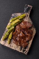 Juicy beef or pork cut into slices with boiled asparagus photo