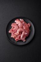 A pieces of raw fresh pork on a wooden cutting board with spices and herbs photo