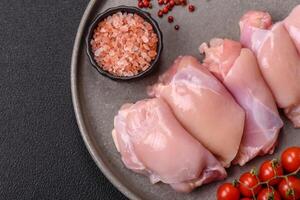 Fresh chicken fillet on a dark concrete table with spices and herbs photo