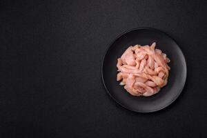 Raw chicken fillet cut into strips with spices and herbs photo