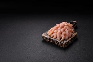 Raw chicken fillet cut into strips with spices and herbs photo