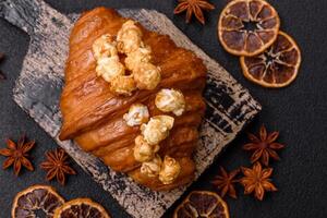 Sweet crispy croissant with salted caramel and glazed popcorn photo