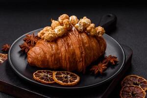 Sweet crispy croissant with salted caramel and glazed popcorn photo
