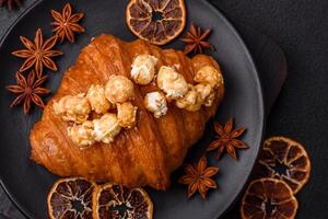 Sweet crispy croissant with salted caramel and glazed popcorn photo