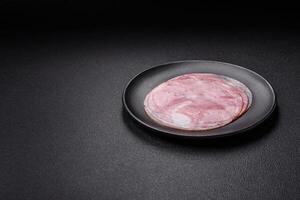 Ham cut into round slices with salt, spices and herbs photo