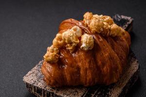 Sweet crispy croissant with salted caramel and glazed popcorn photo