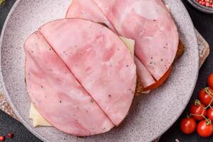 Sandwich with toast, ham, cheese, tomatoes, salt, spices and herbs photo