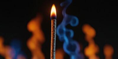Burning matchstick with colorful abstract flames on black background. photo