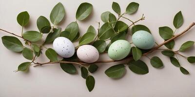 easter eggs and branches with green leaves on a light background, easter flat lay concept. photo