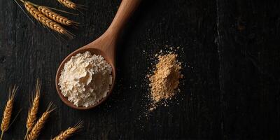 Dark black wooden background with wheat flour scattered providing copy space image from a top view ideal for cooking or baking themes. photo