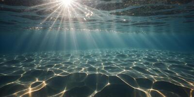 A shot from underneath the water with rays of sunlight shining through the surface of a solarpowered pool. photo