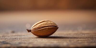 Macro Shot of Solitary Almond on Rustic Wooden Surface with Blurred Background. photo