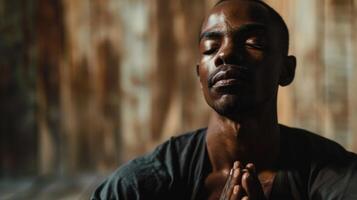 A man sitting with his eyes closed and his hands resting on his knees, a serene and peaceful expression on his face as he practices deep and intentional breaths. photo