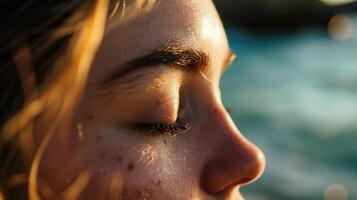 The closeup of a womans face, with gentle waves painted on her eyelids and a soft glow highlighting her features, evokes the serenity of a peaceful ocean. photo