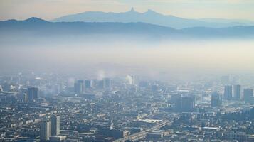 The concrete jungle is obscured by a thick layer of smog in this aerial view, illustrating the impact of urban pollution. photo