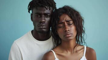 An interracial couple standing apart from each other both with tears running down their photo