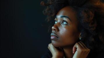 A woman of color staring off into the distance her hands fidgeting as she struggles with the memories of her trauma photo