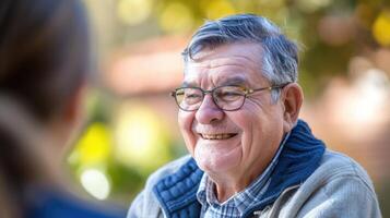 A middleaged man with autism a broad smile on his face as he engages in a conversation with his the photo