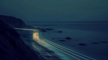 The headlights of cars traveling along the coast leave behind a sparkling wake as they p reflecting the everchanging nature of a coastal journey photo