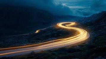 A tight turn on the mountain road with the headlights of a single car illuminating the way photo