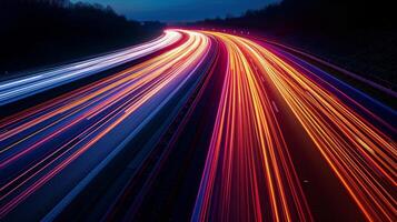 The continuous flow of traffic on the highway captured in a long exposure shot transforming the roads into a canvas of vibrant light streaks photo