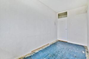An empty room with a blue floor and white walls photo