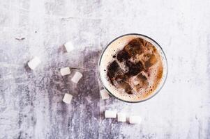 Close up of fusion drink of cola and marshmallow in a glass on the table top view photo