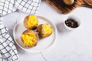 Appetizing jacket potatoes on a white plate on the table photo