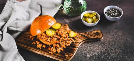 Spicy burger with minced meat and pickles on a board on a table web banner photo