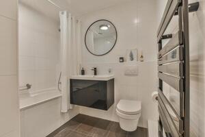 A bathroom with a toilet, sink, and mirror photo