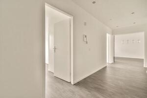 Empty hallway with wooden floor and white walls photo