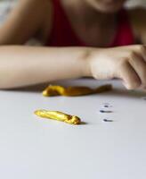 Child playing with a gold slime photo