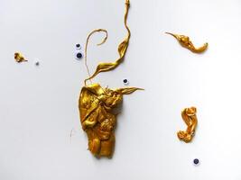Gold slime and handmade details on white background photo